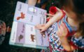 child reading book with mother in garden
