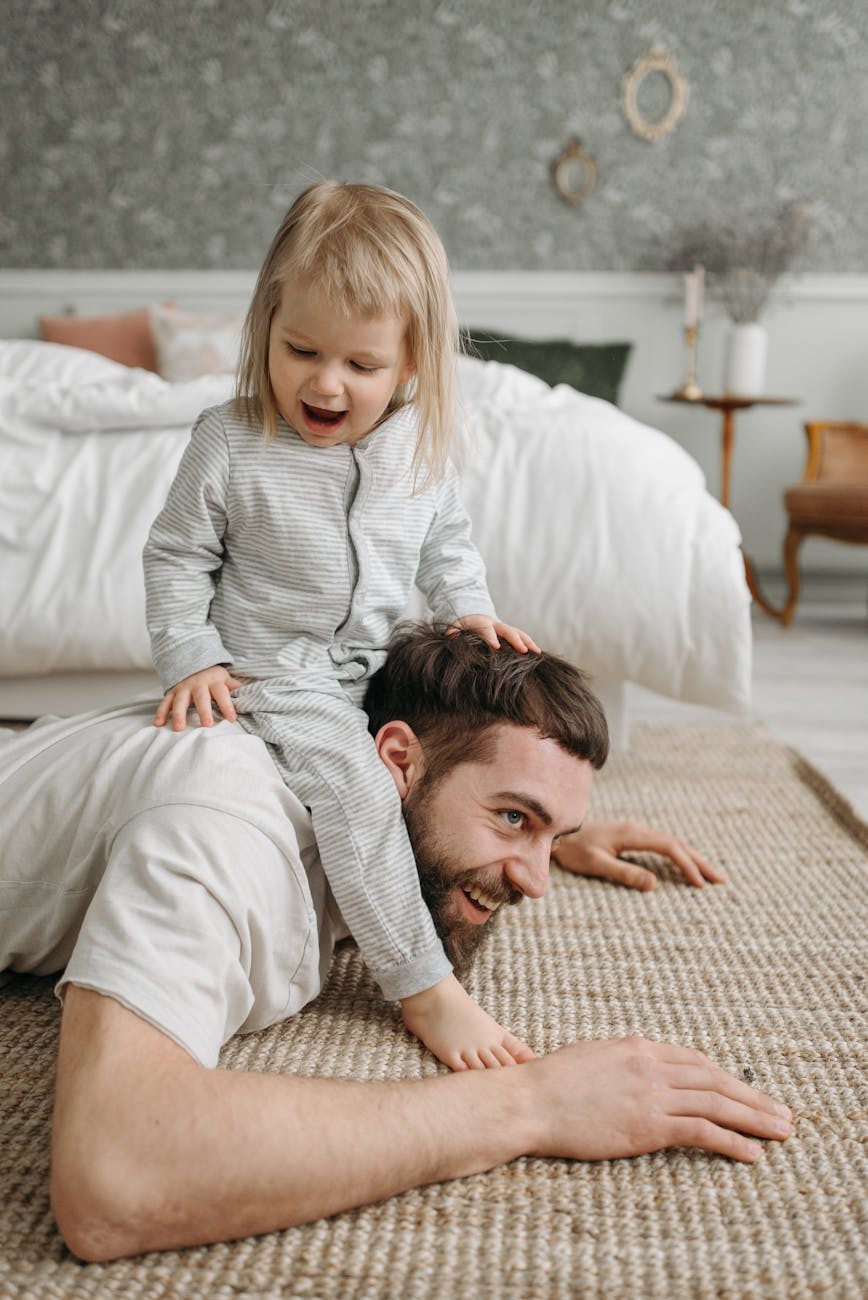 a cute baby sitting on her father s back