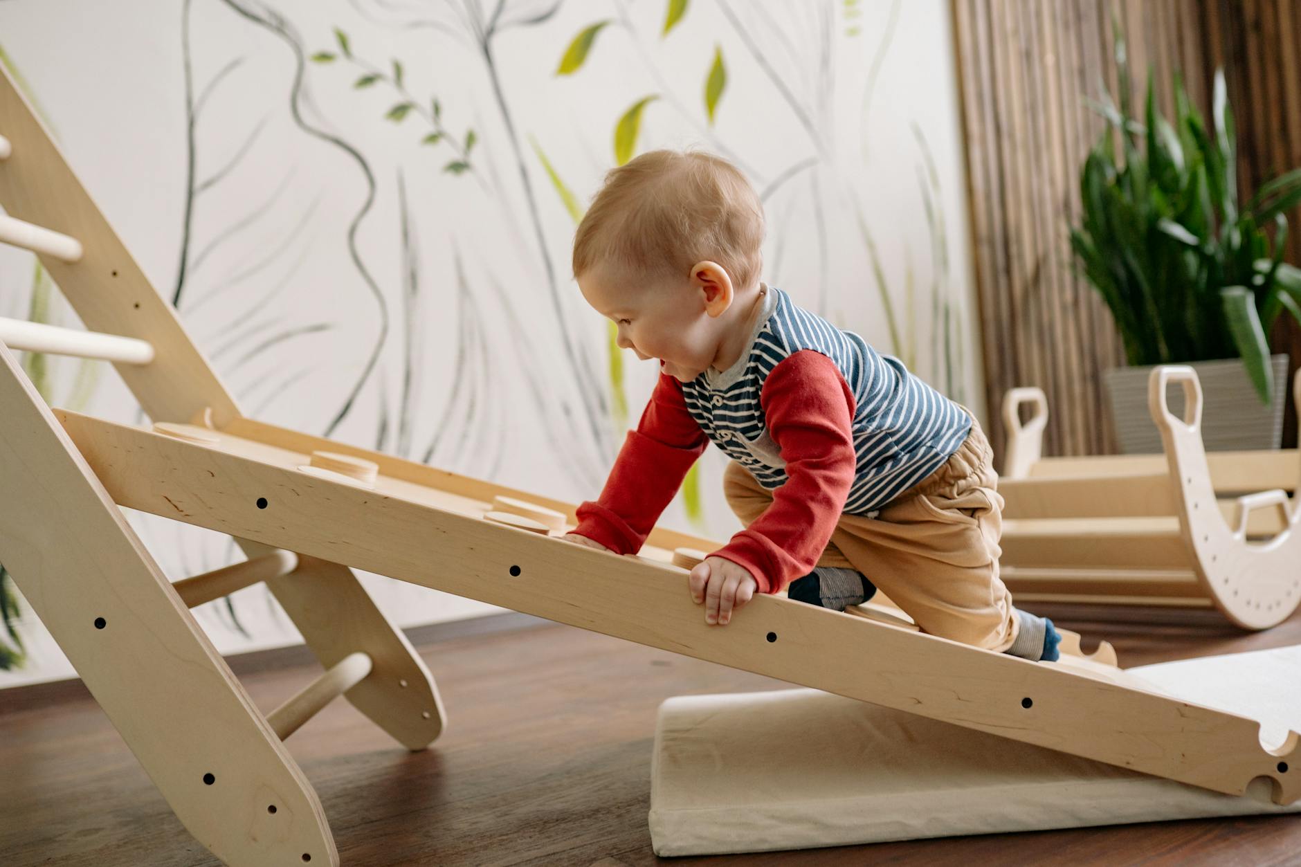 happy toddler climbing up a wooden ladder
